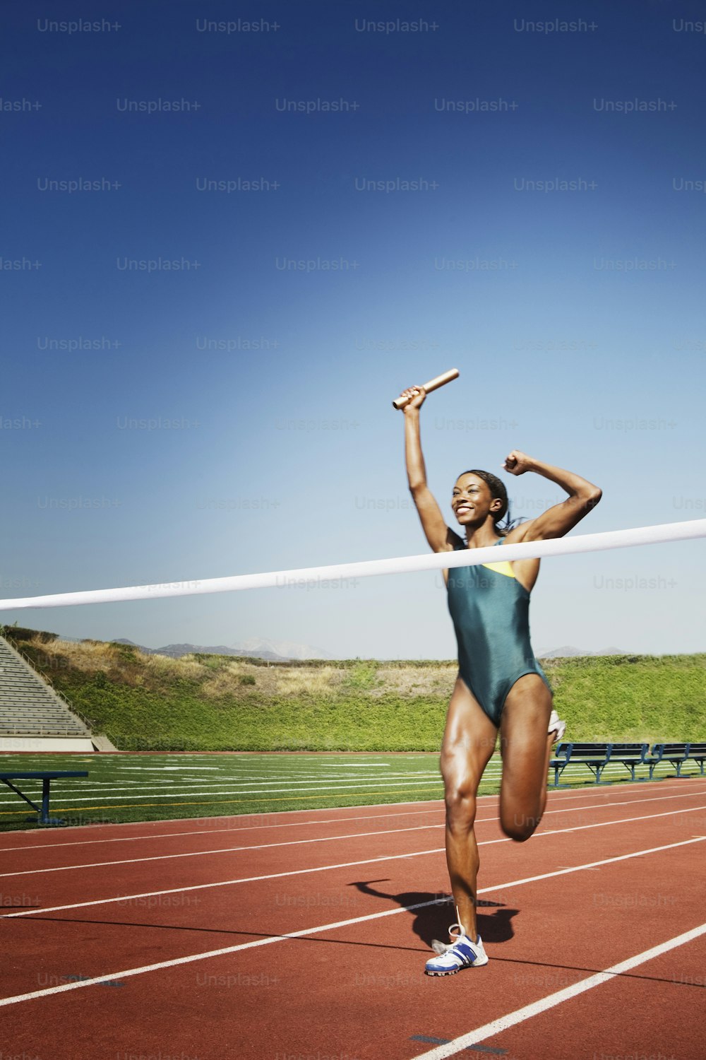 a woman is running on a track with her arms in the air