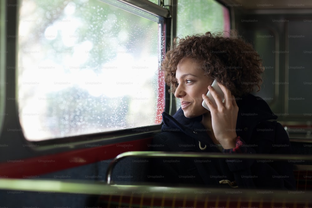 Eine Frau, die während der Busfahrt mit einem Handy telefoniert