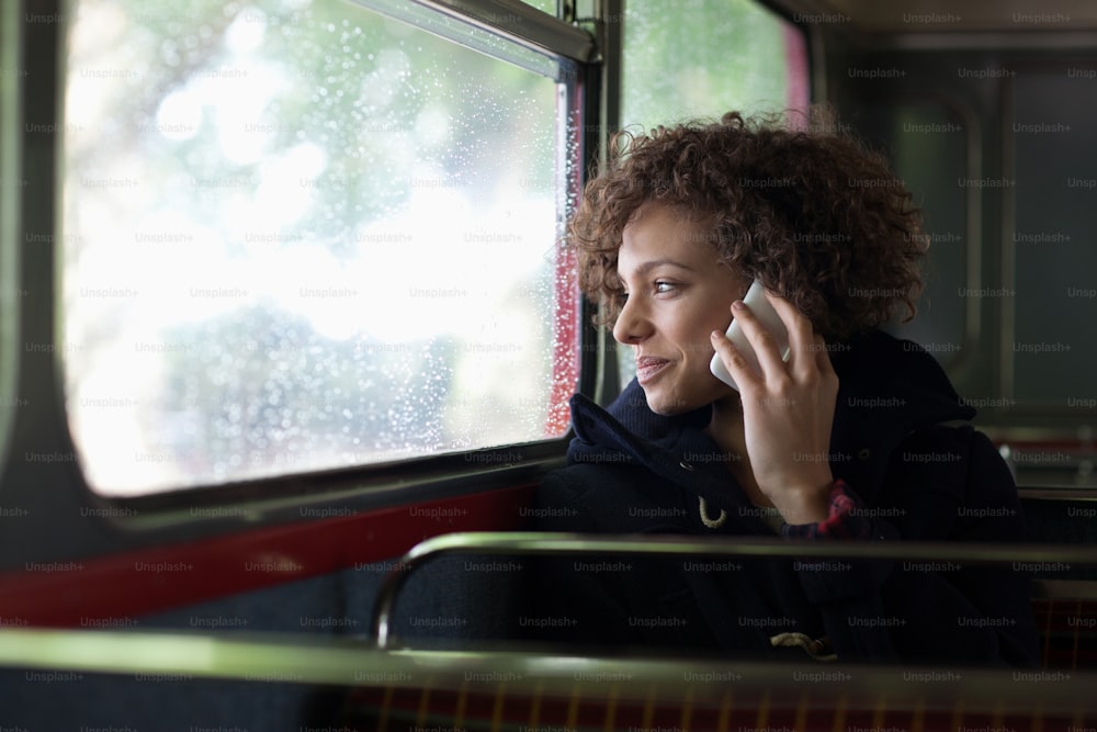 Una donna che parla al cellulare mentre guida un autobus