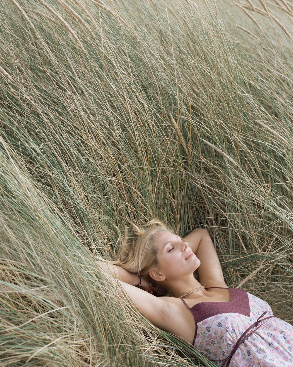 Une femme allongée dans un champ d’herbes hautes