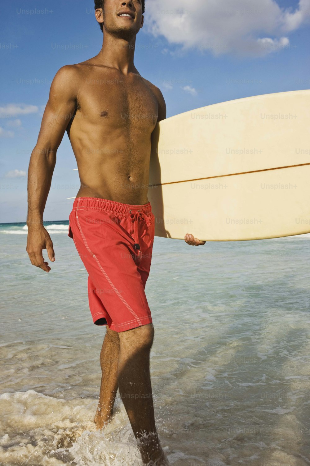 Un homme sortant de l’océan avec une planche de surf