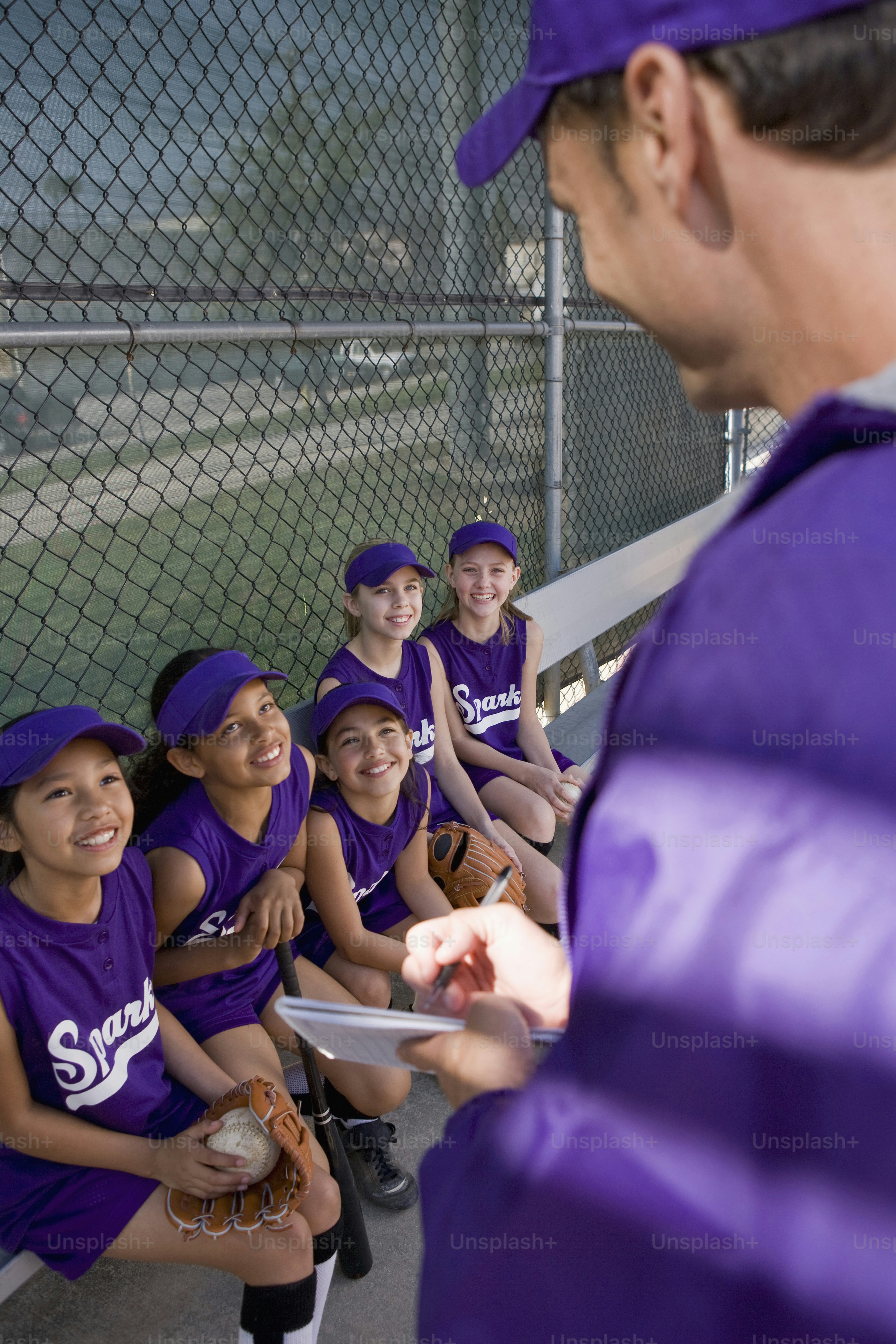 a group of young girls sitting on a bench next to each other