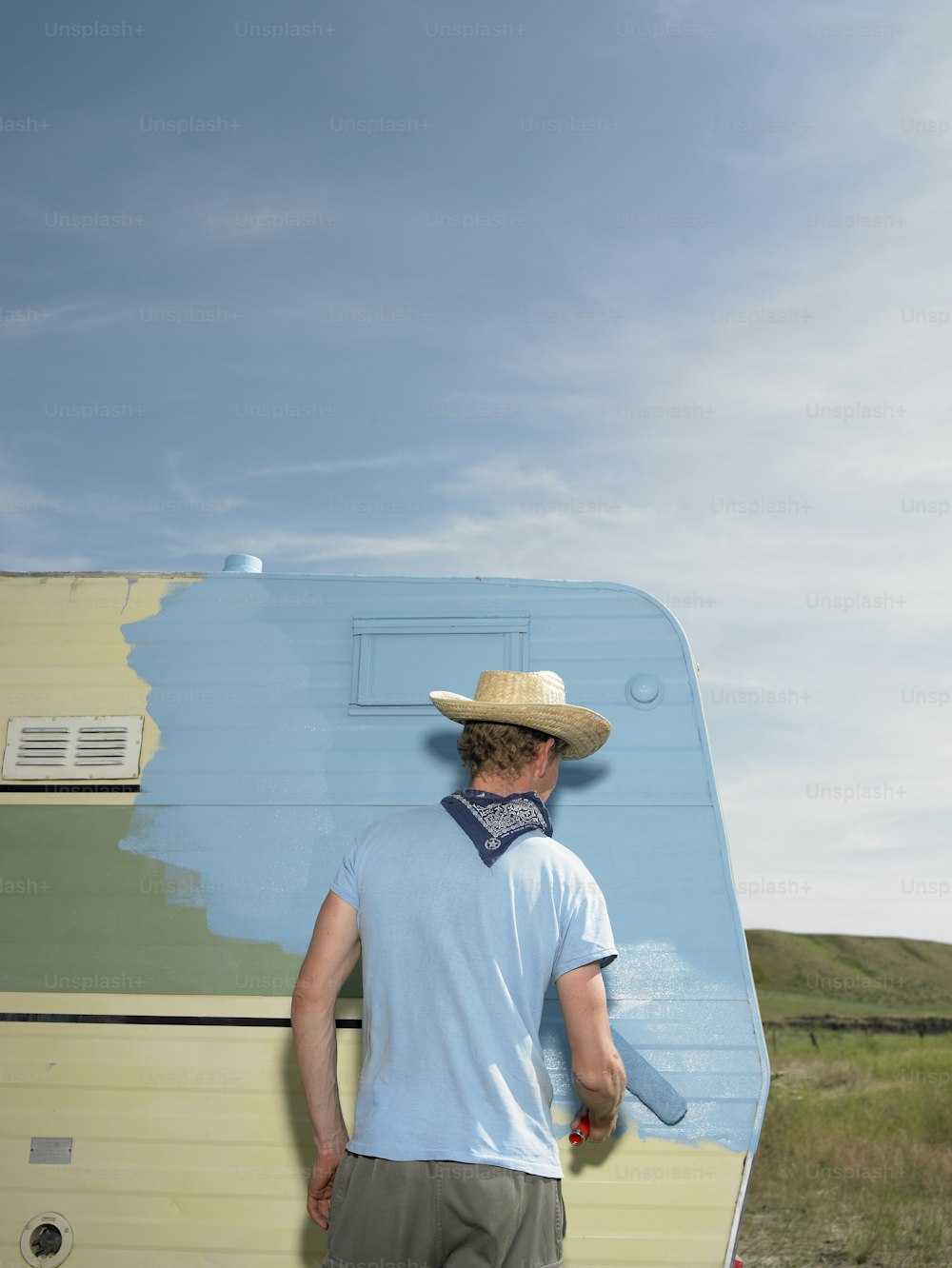 a man in a straw hat standing in front of a trailer
