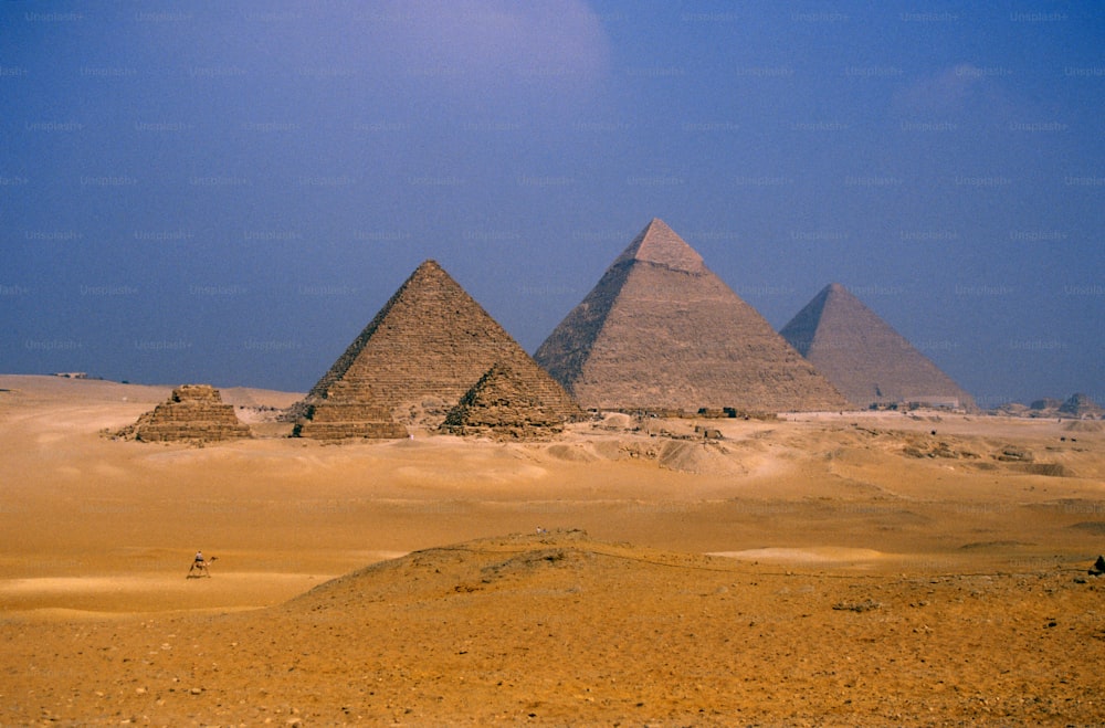 a group of three pyramids in the desert