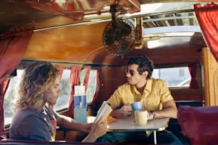 two men sitting at a table in a bus