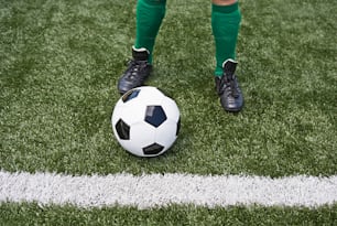 a soccer player standing on a field with a soccer ball