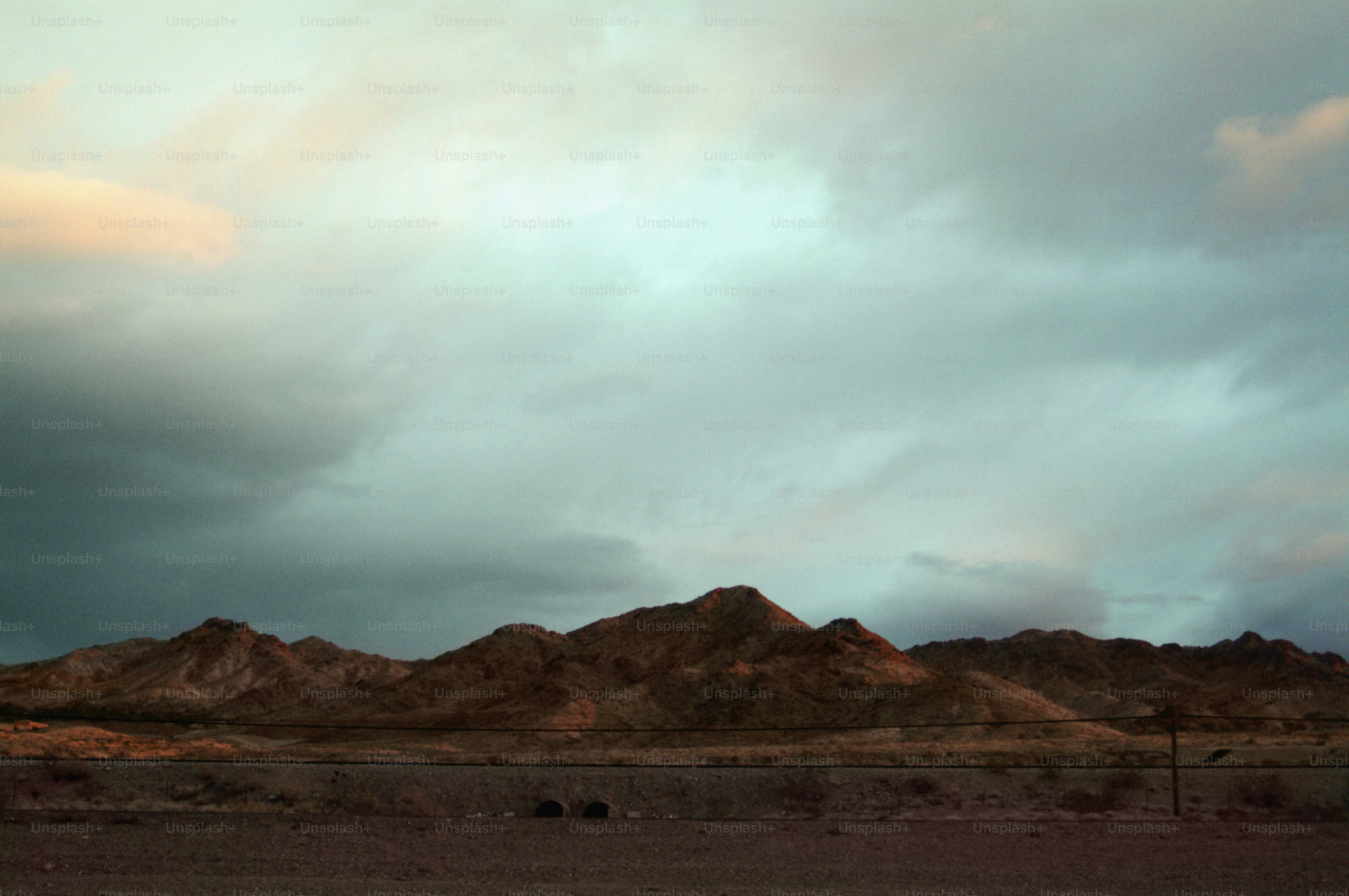 a group of mountains under a cloudy sky