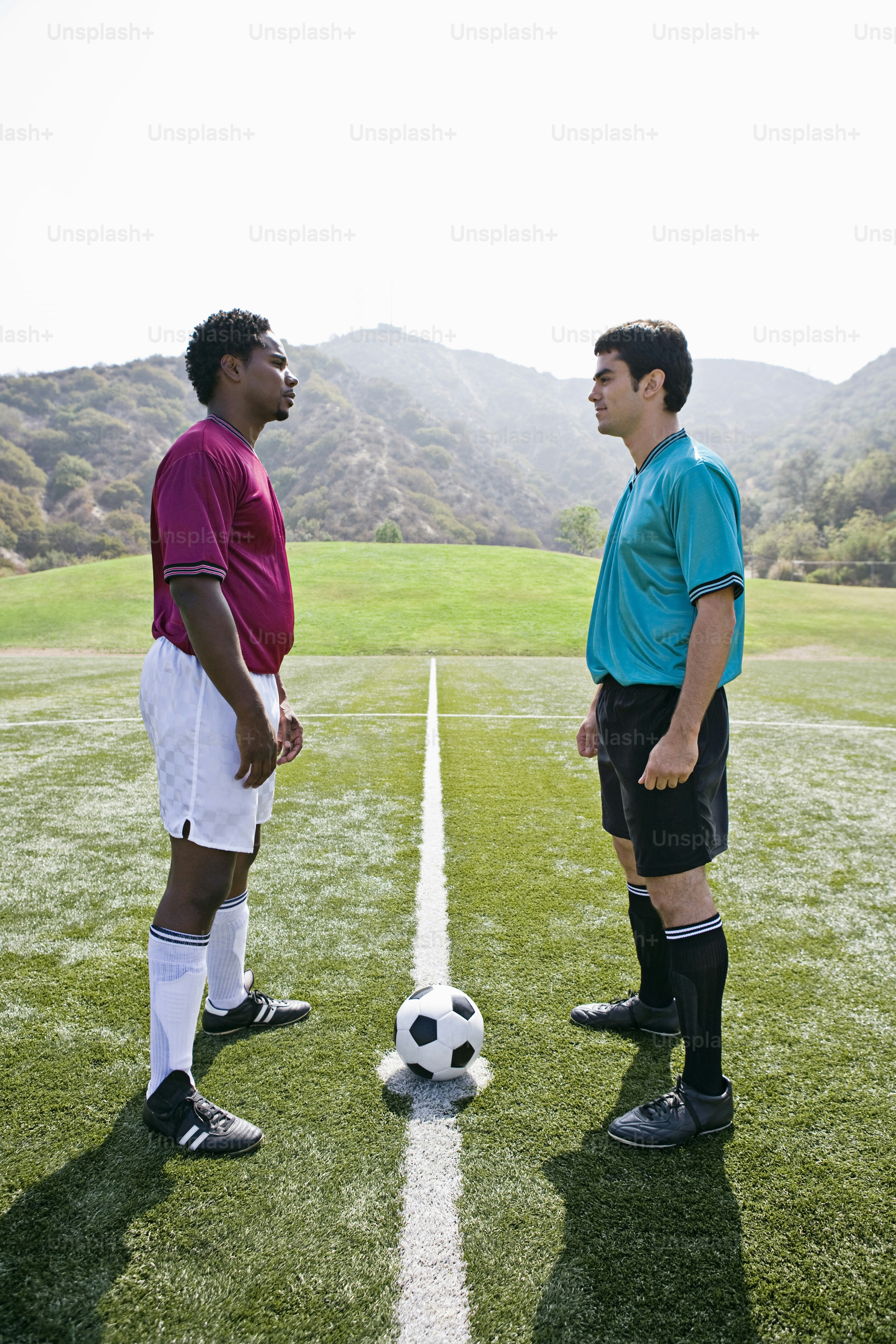a couple of men standing on top of a soccer field