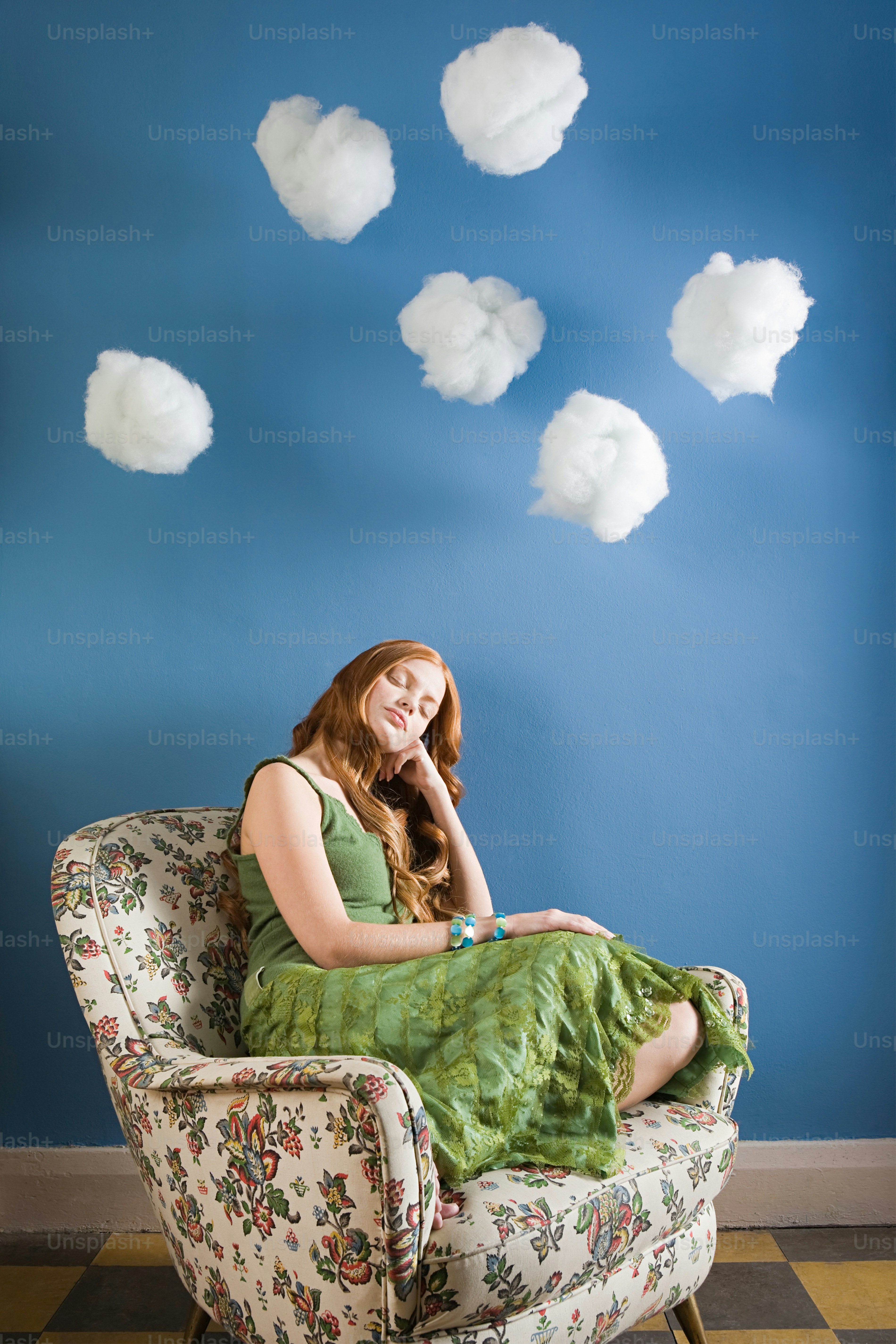 a woman in a green dress sitting on a chair
