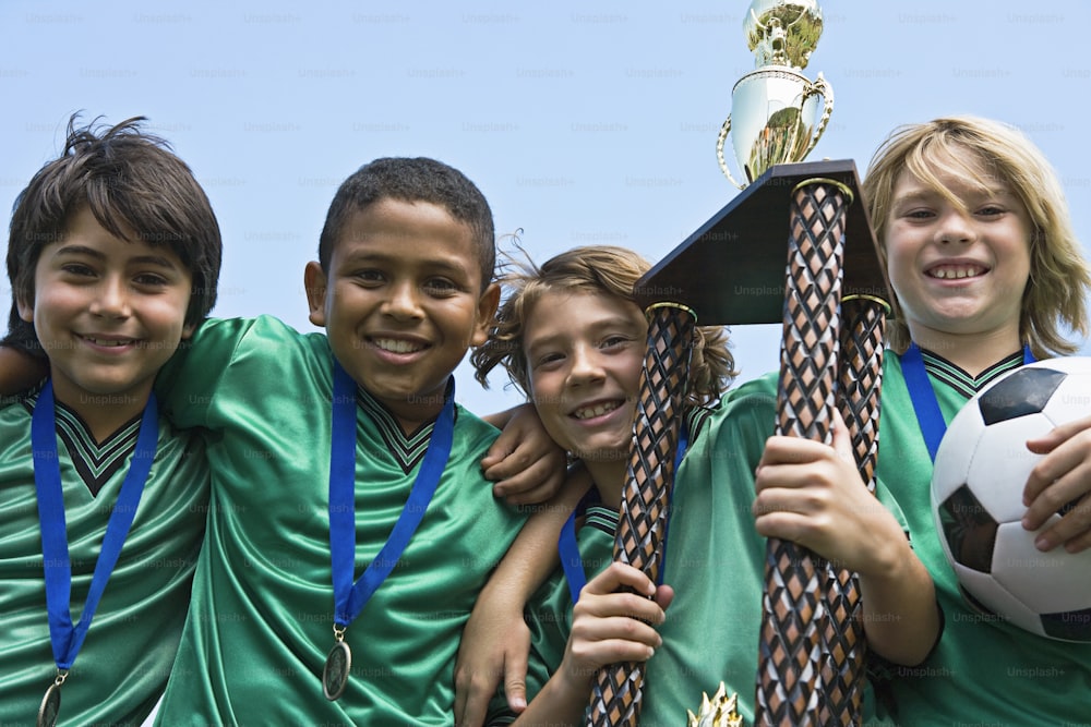 a group of young boys standing next to each other holding a soccer ball