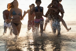 a group of young women running into the ocean