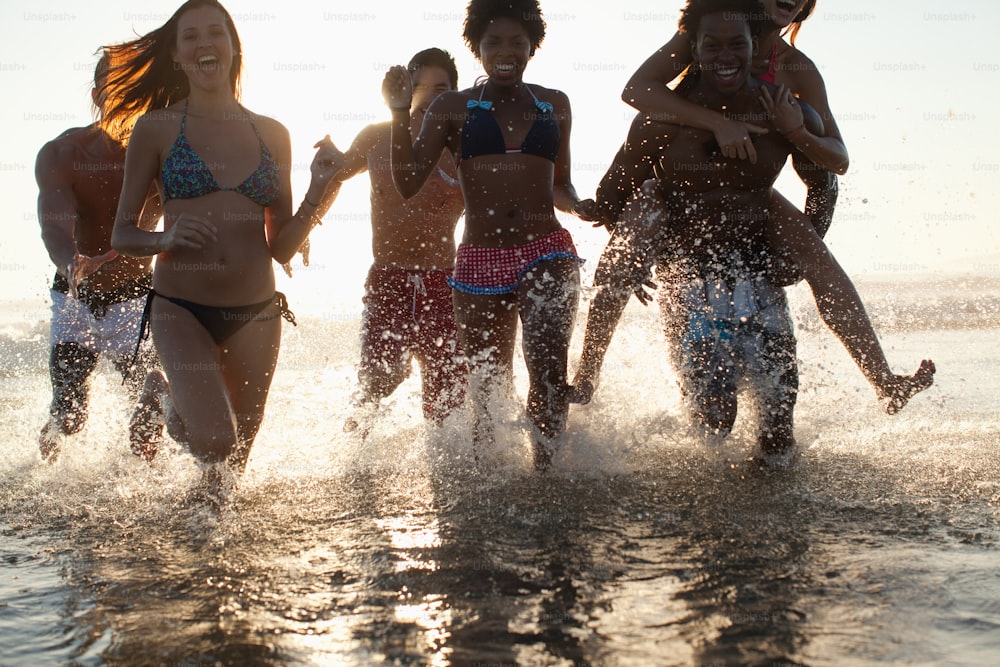 a group of young women running into the ocean