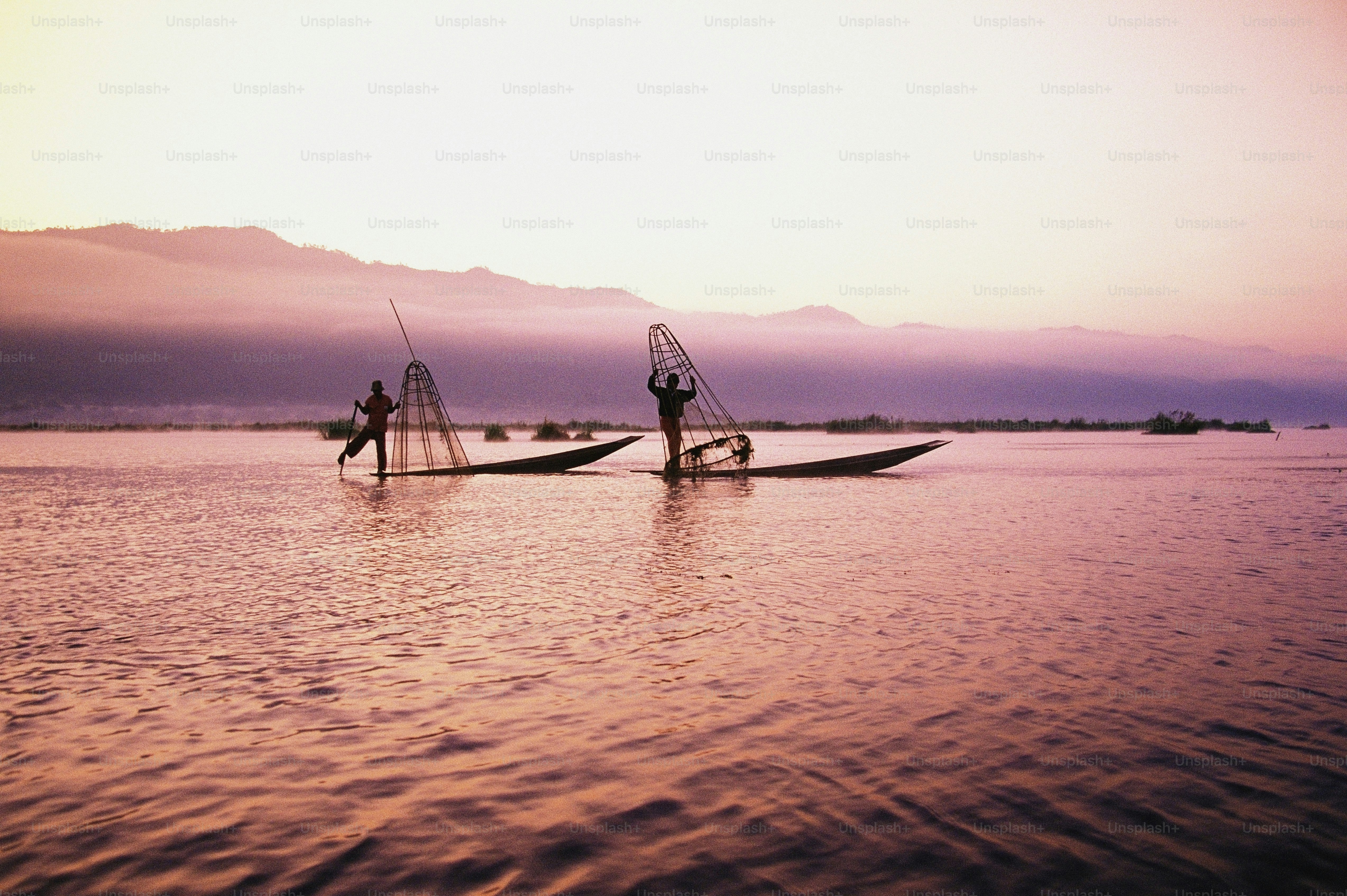 a couple of people standing on top of a boat in the water