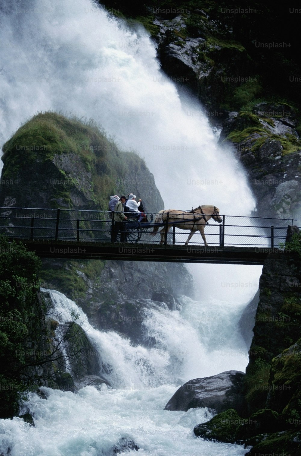 eine Pferdekutsche, die eine Brücke über einen Fluss überquert