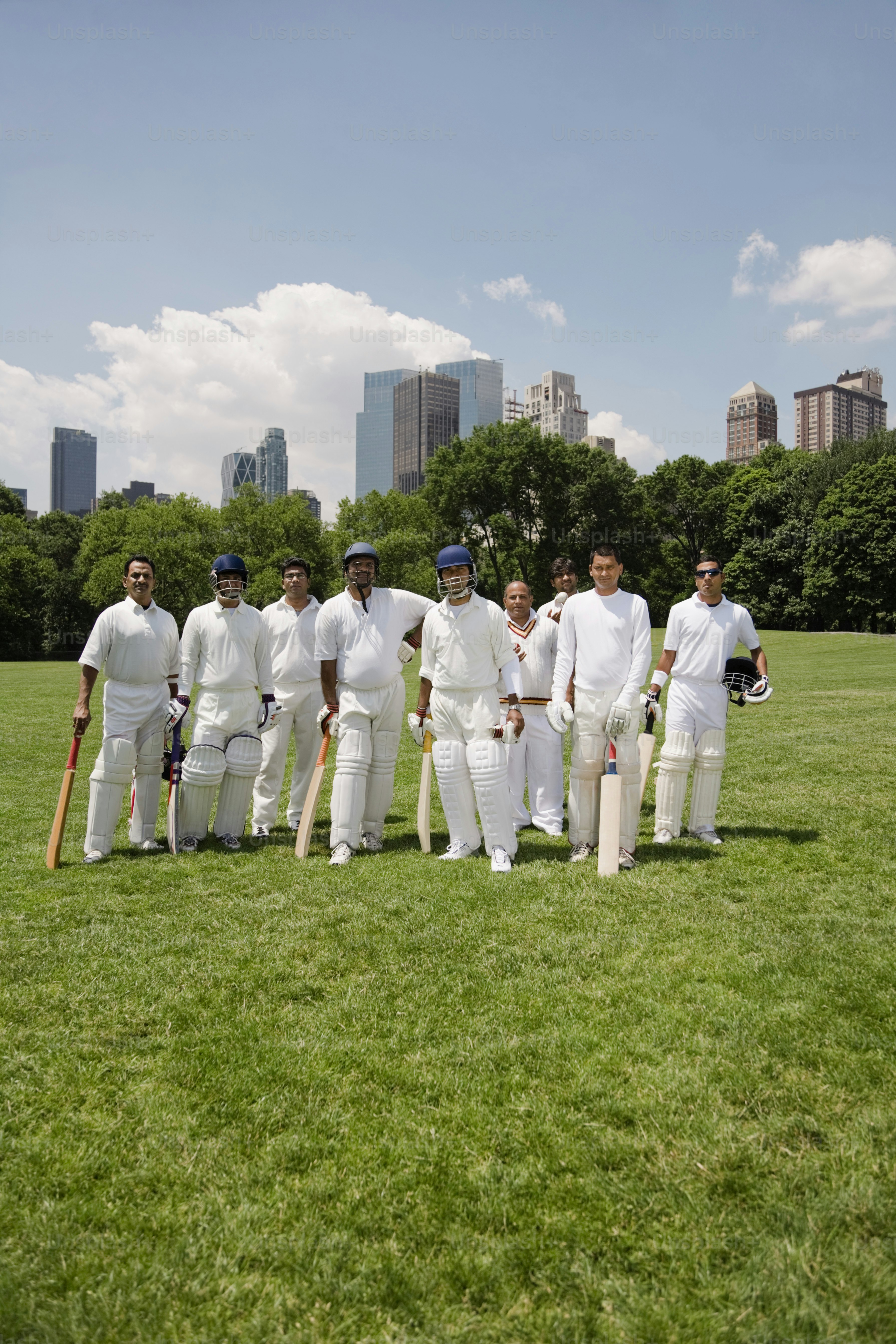 a group of men standing on top of a lush green field