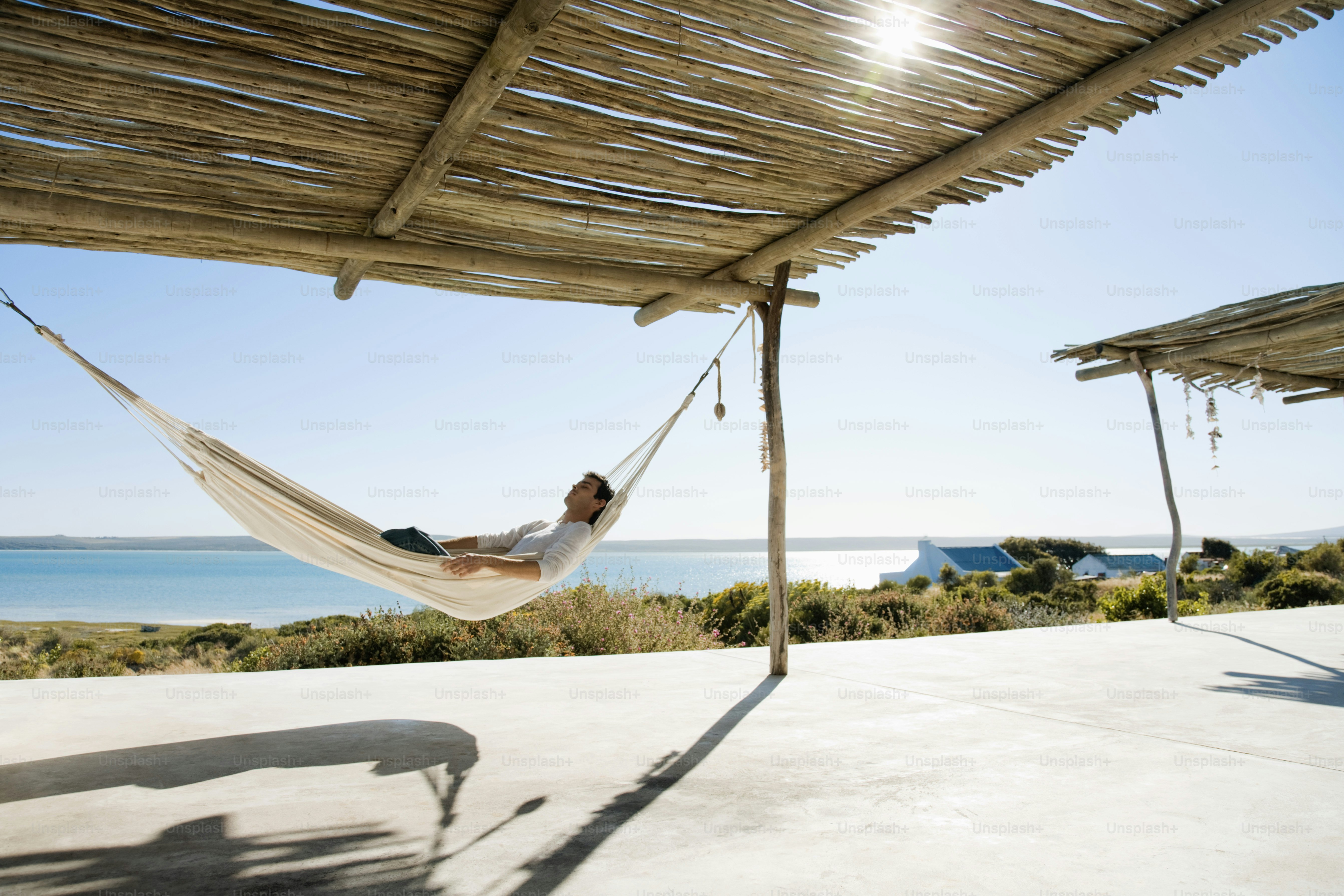 a woman laying in a hammock on the beach