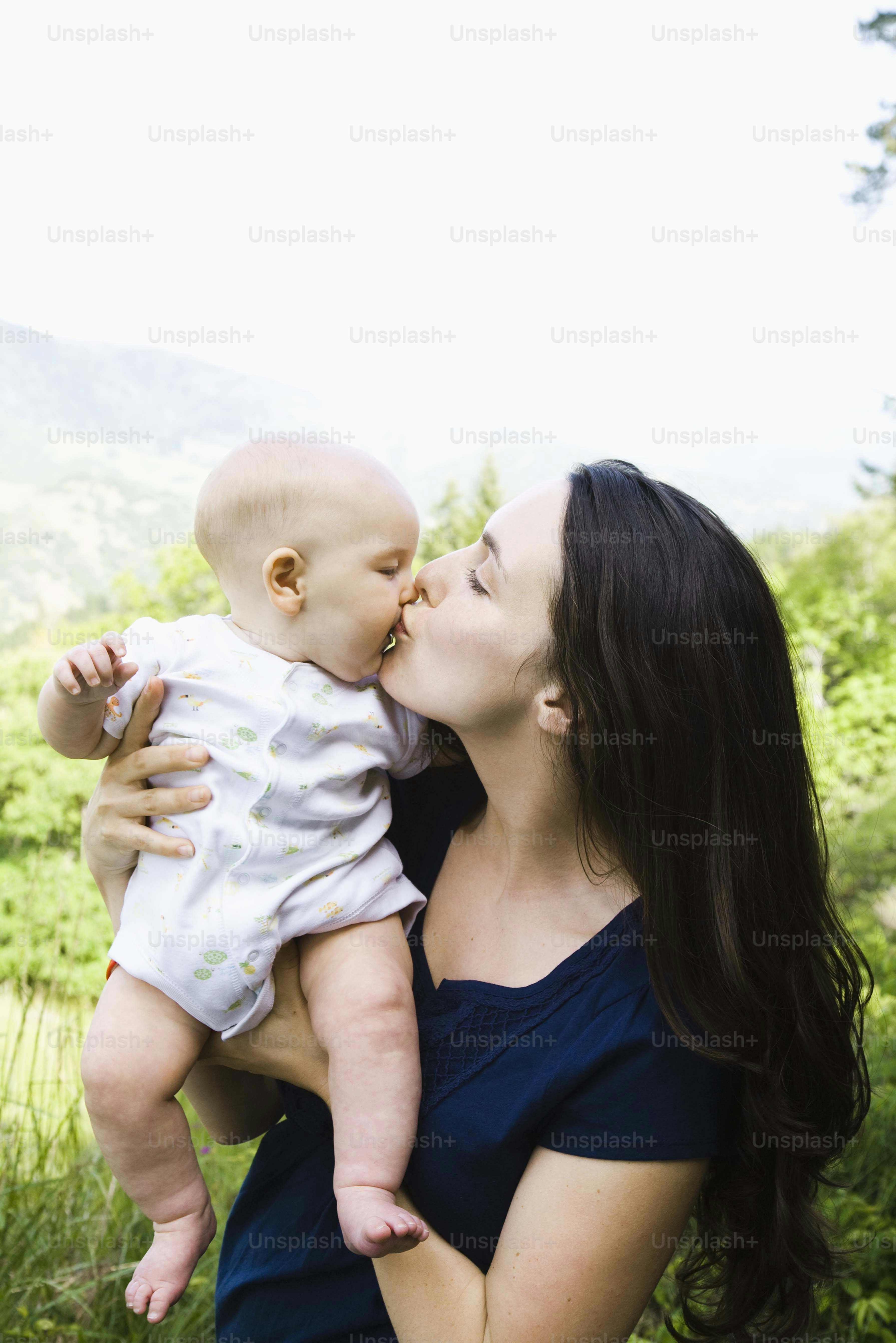 Una mujer sosteniendo a un bebé en sus brazos foto – Imagen de Padre en ...