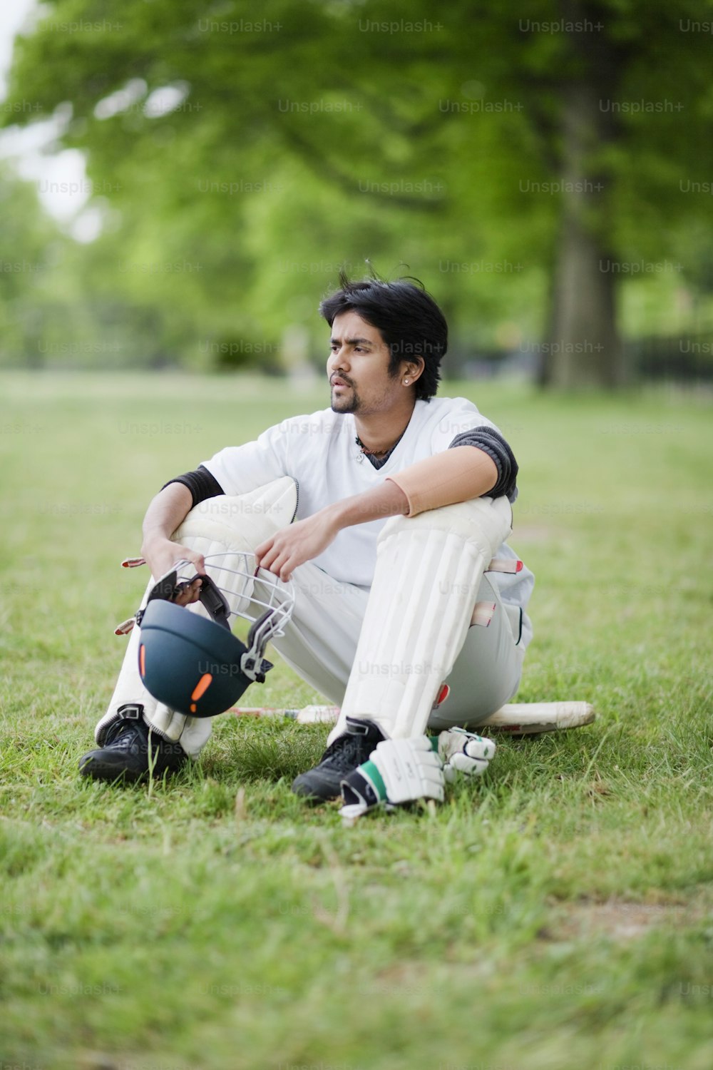 um homem sentado em cima de um campo verde