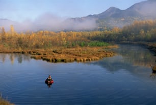 a man in a boat fishing on a lake