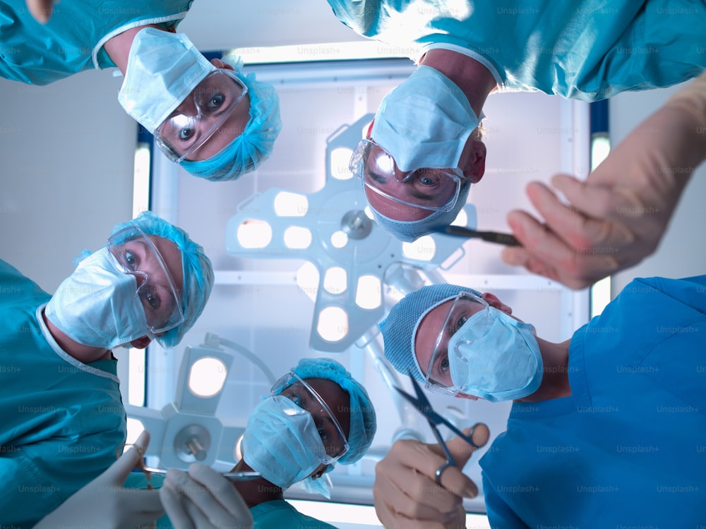 파란색 수술복을 입은 외과 의사 그룹이 수술을 하고 있습니다