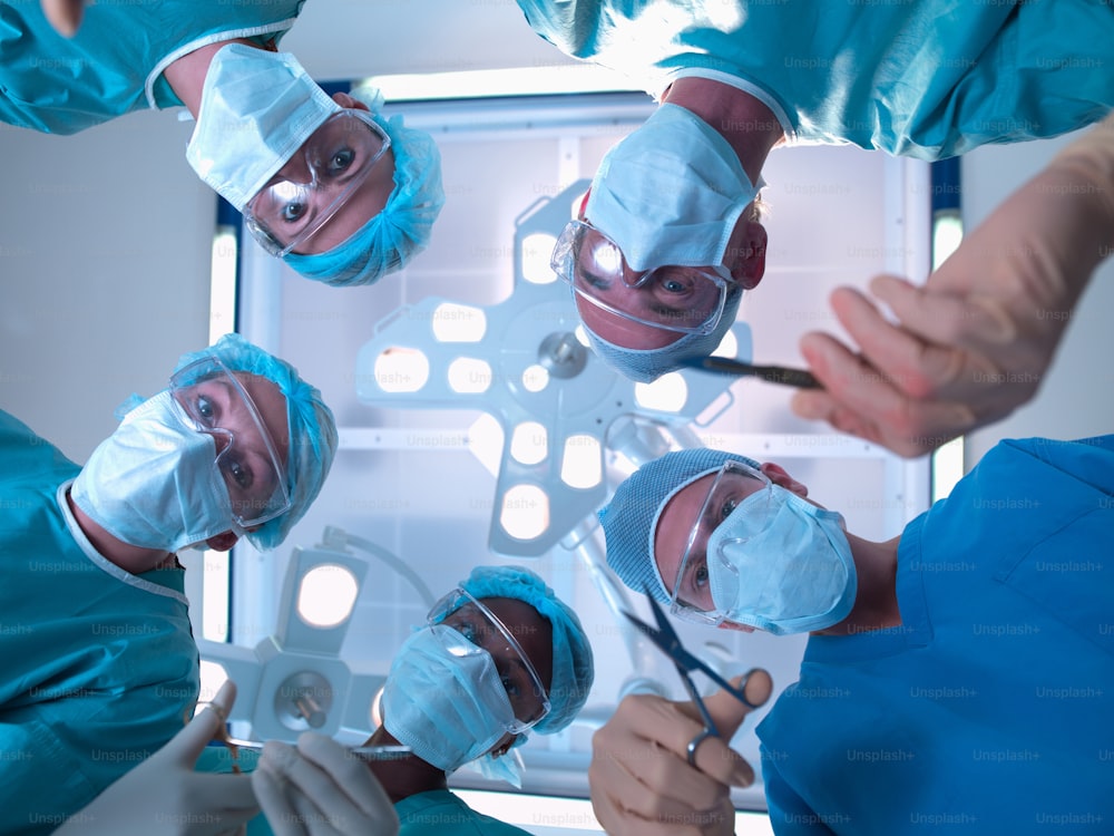 Eine Gruppe von Chirurgen in blauen Kitteln operiert