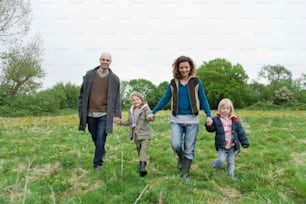 a family walking through a field holding hands