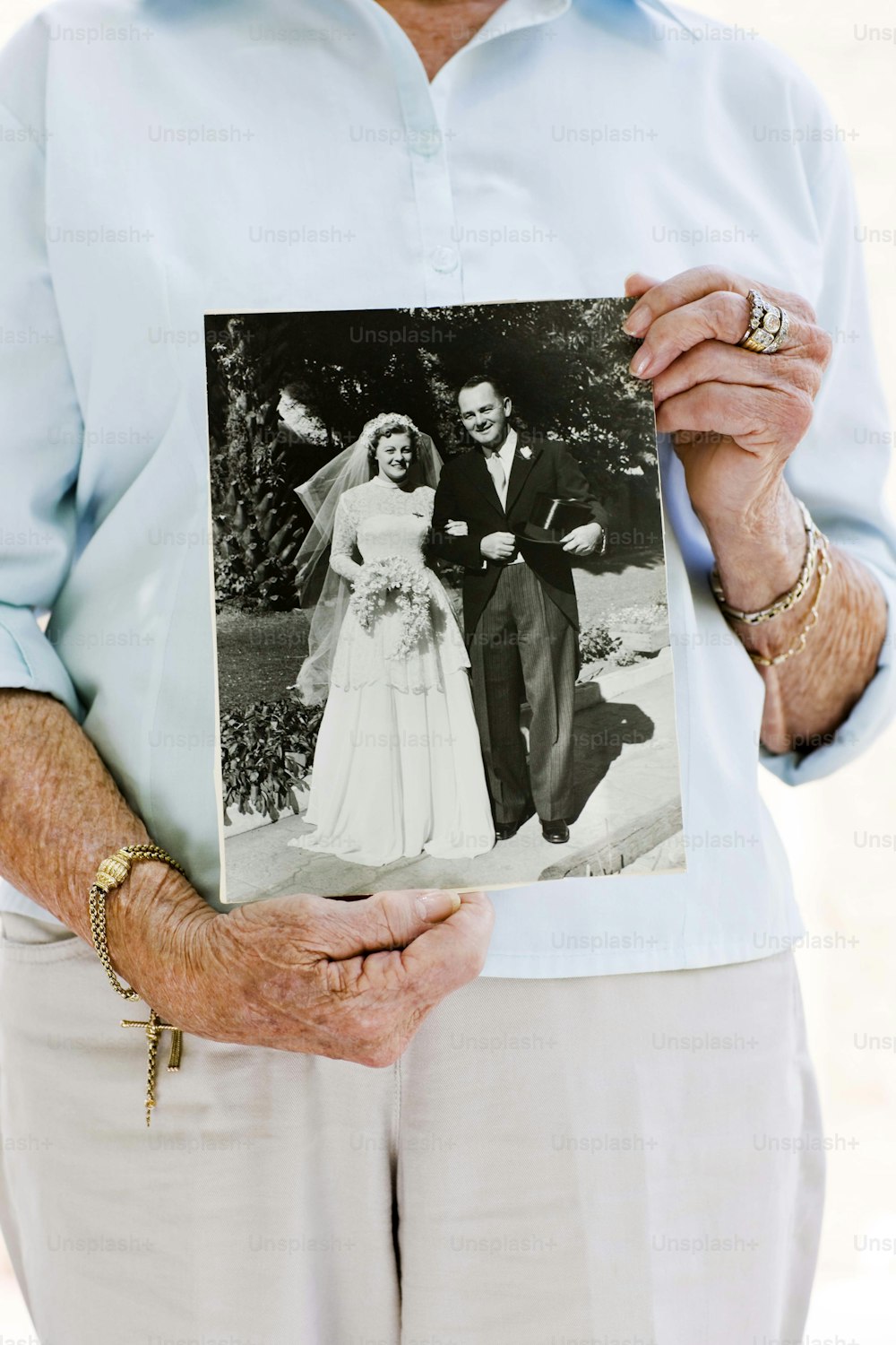 a man and a woman holding a picture of a bride and groom