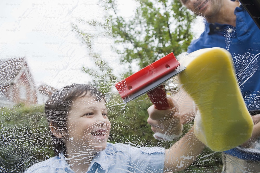 Ein Kind spielt im Regen mit einem Fön