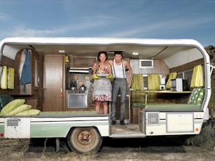 um homem e uma mulher parados na parte de trás de um trailer