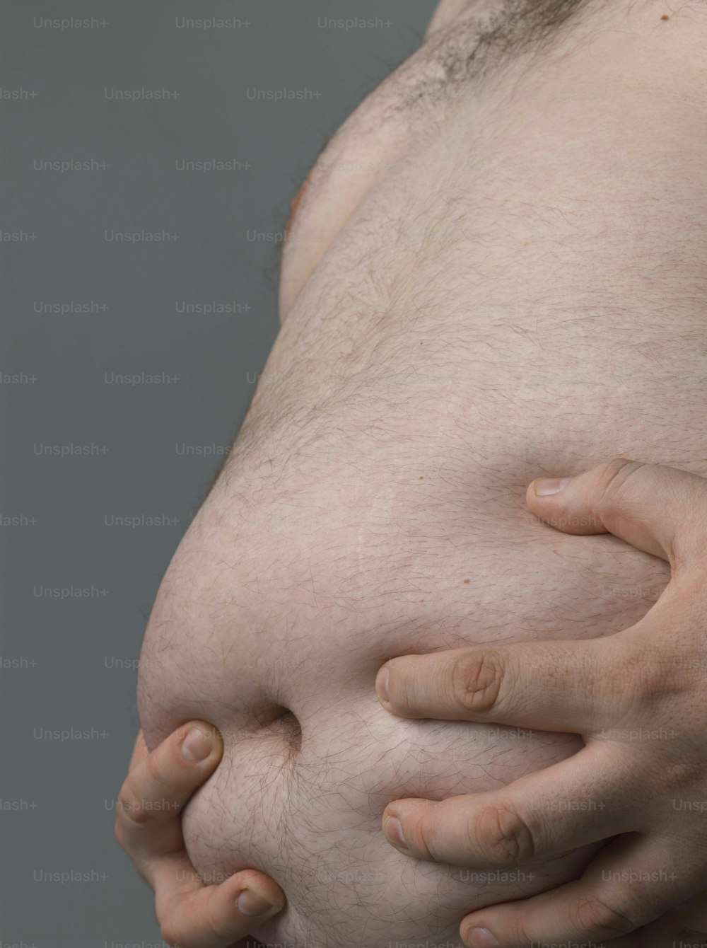 um close up de uma pessoa segurando seu estômago