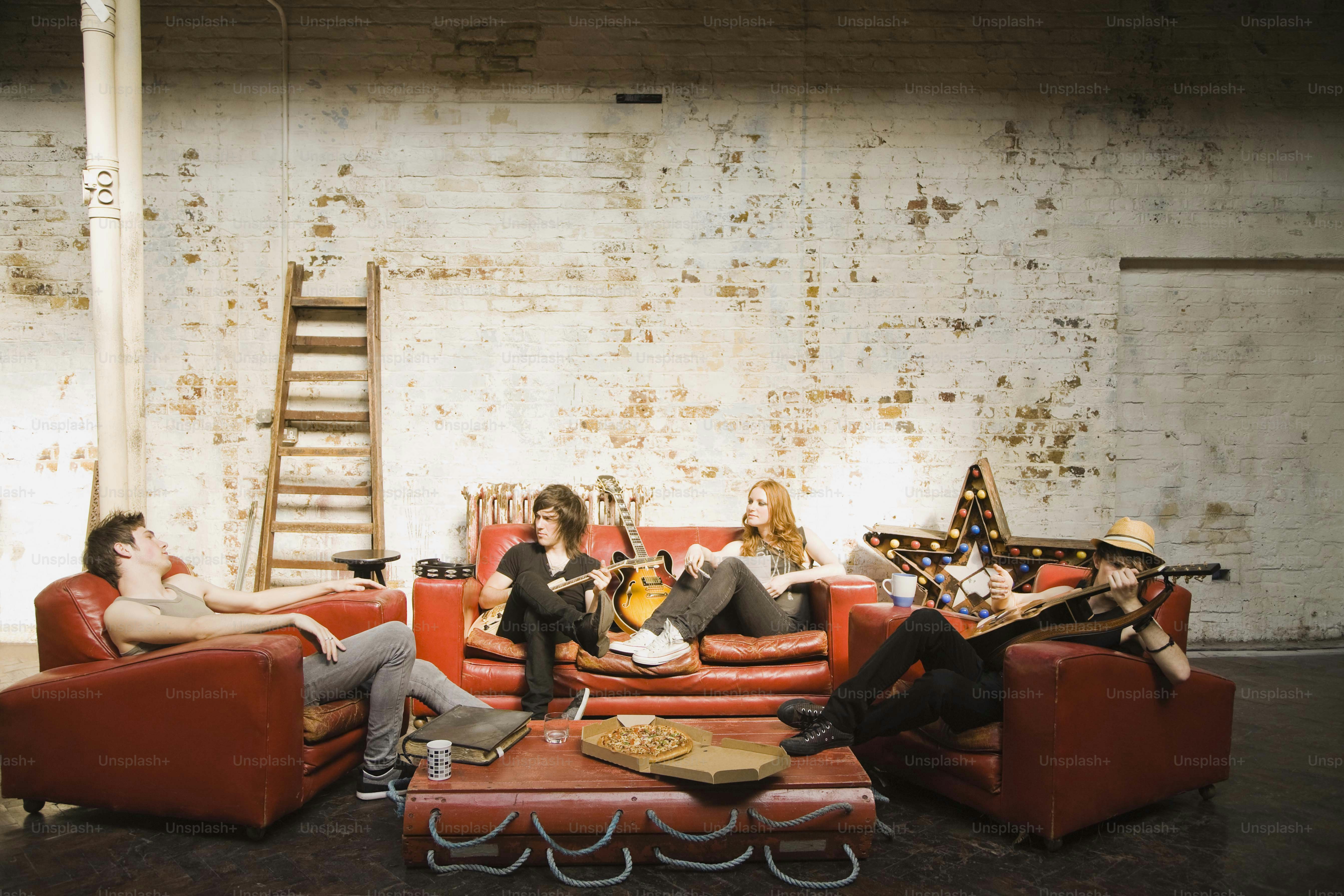 un groupe de personnes assises sur des canapés rouges