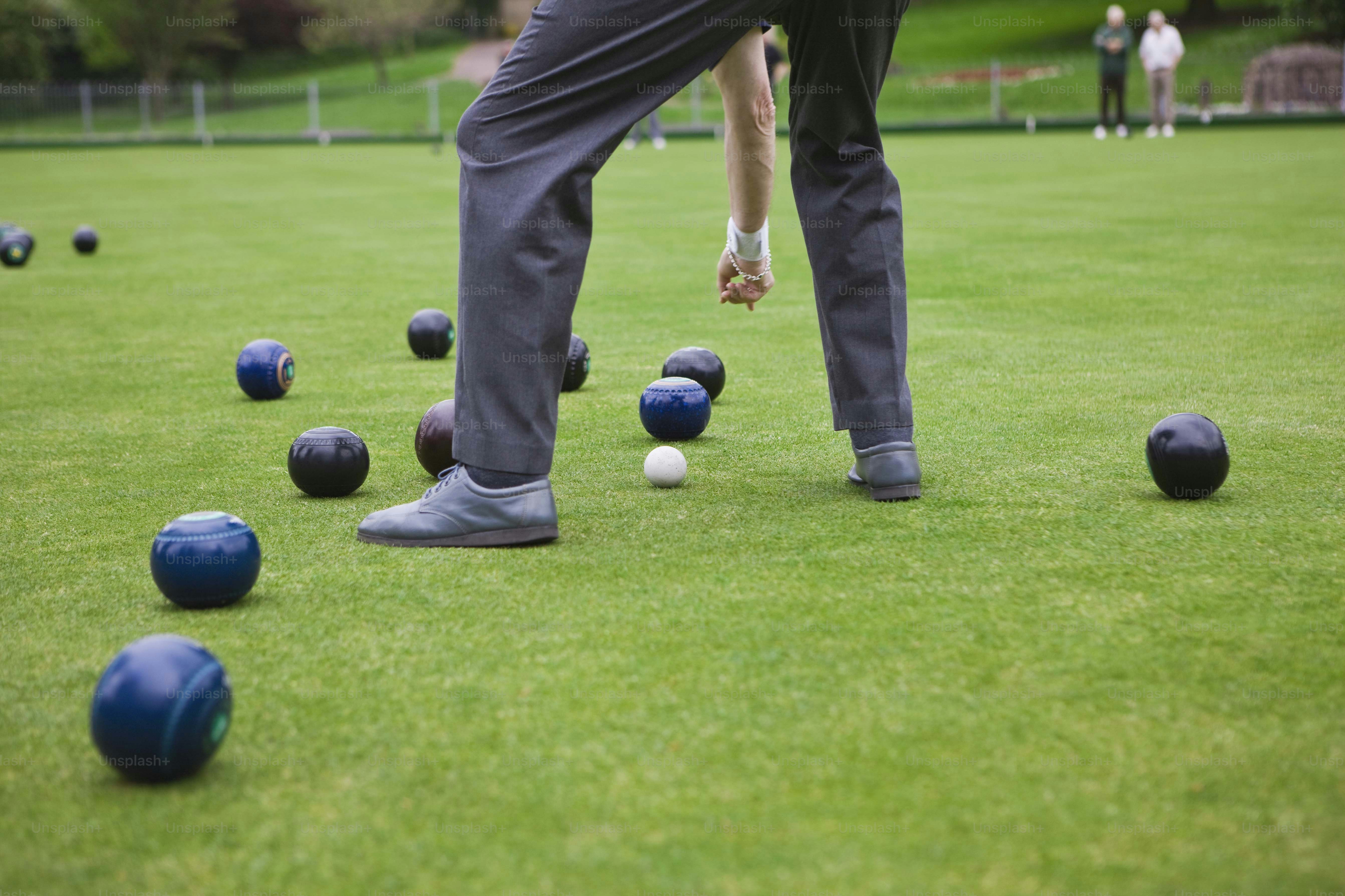a group of people playing boccquet on a lawn