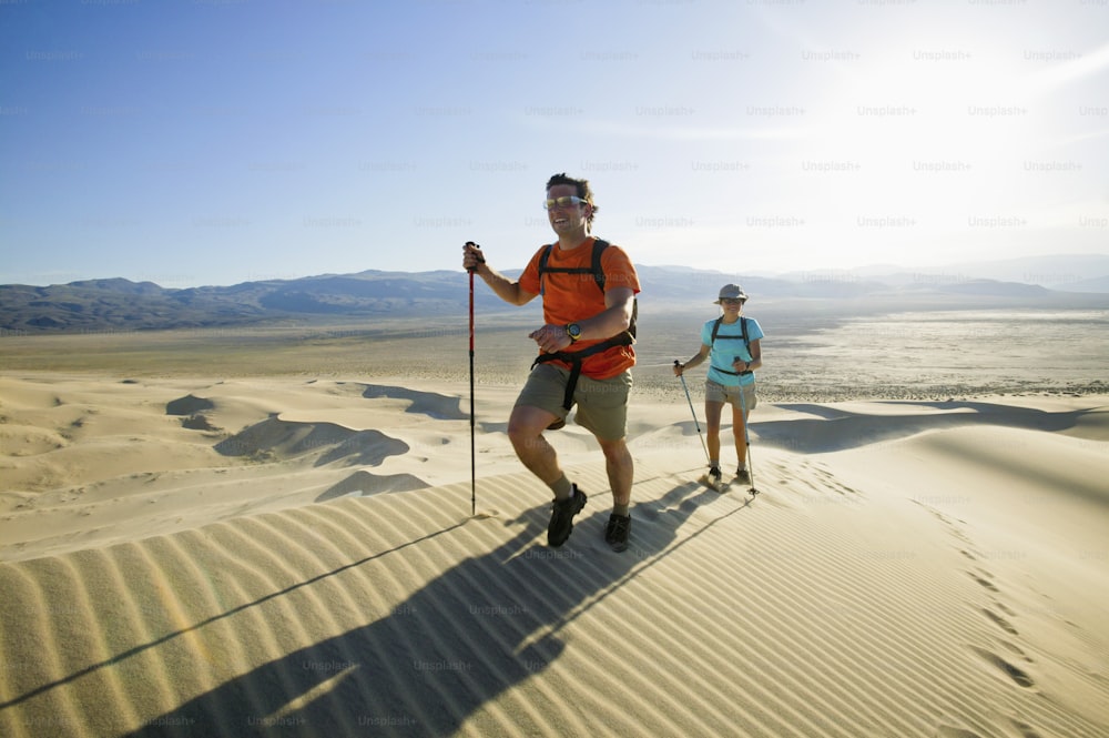 a man and a woman hiking in the desert