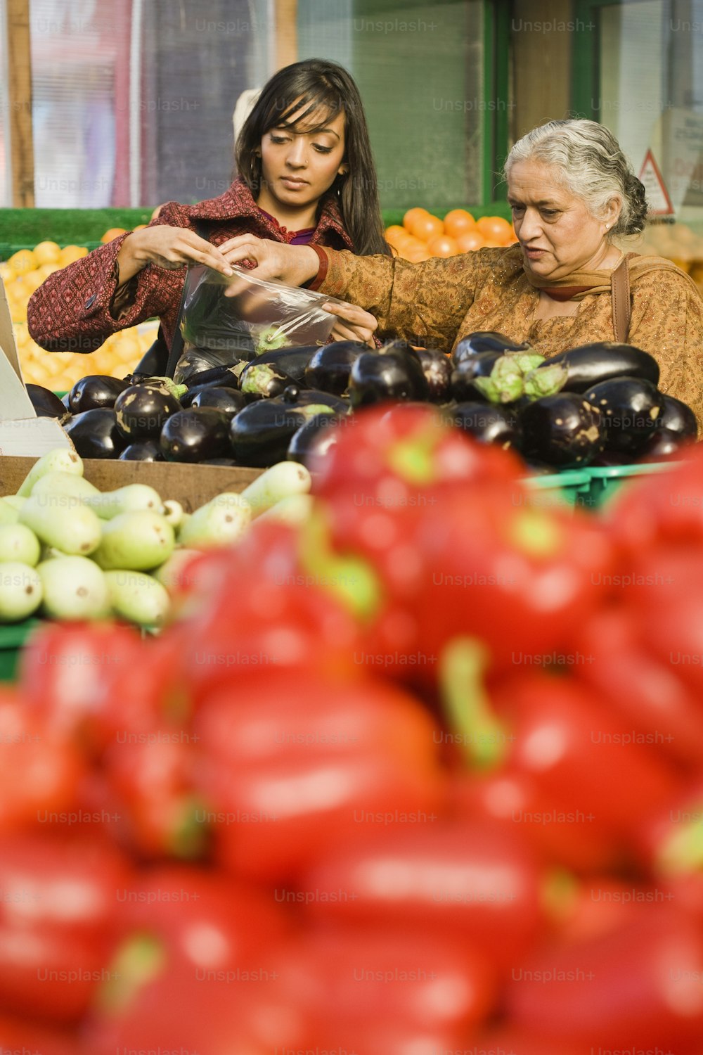 Un grupo de personas de pie alrededor de una mesa llena de frutas y verduras