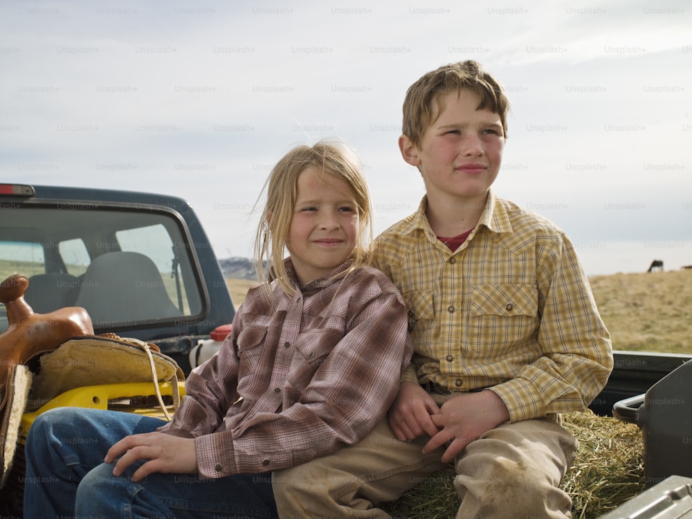 Frère et sœur à l’arrière du coffre de pick-up à Big Timber, Montana