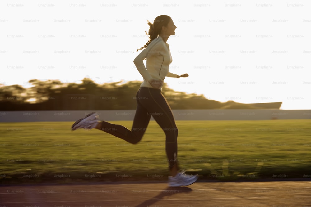 a woman running in a park at sunset