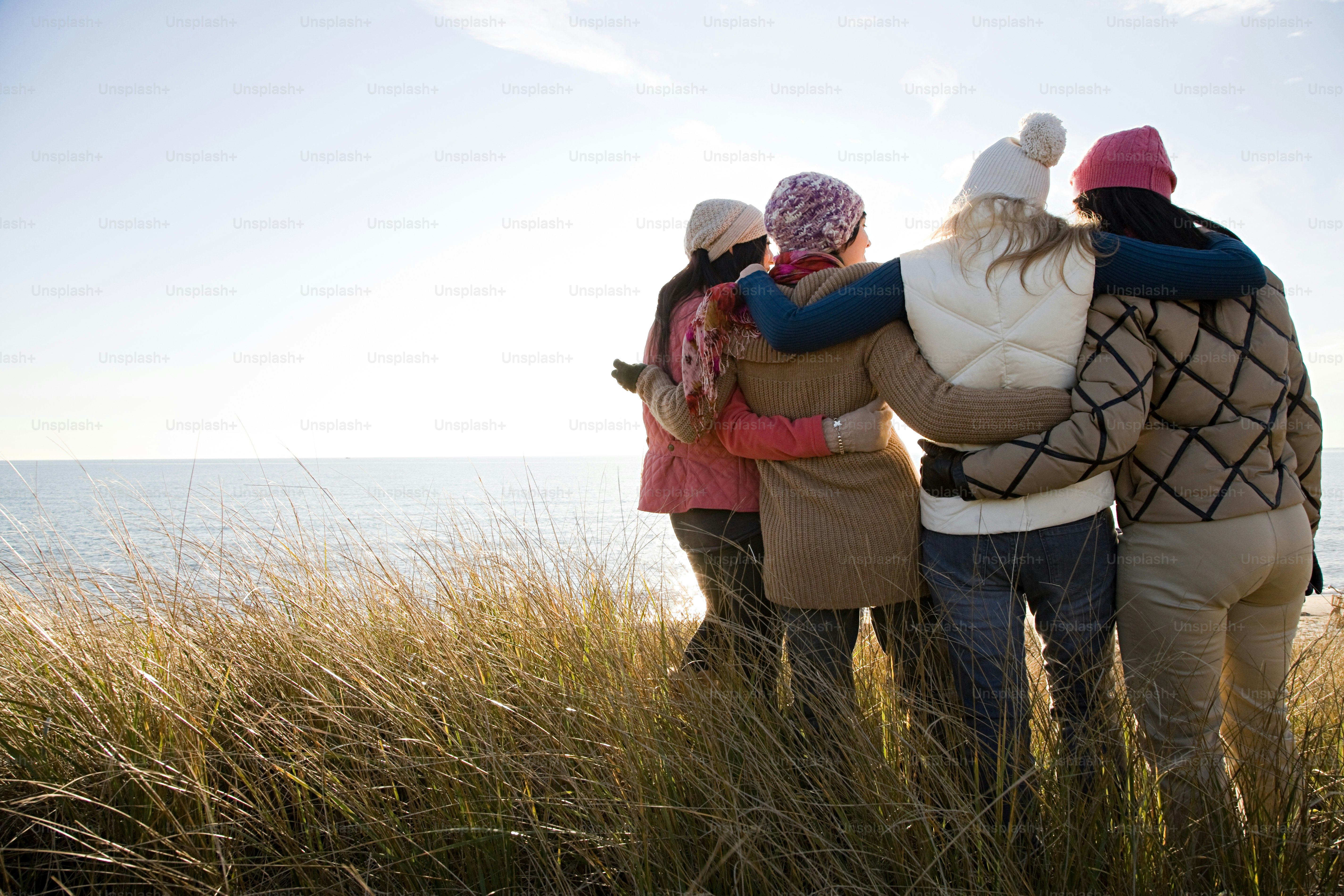 a group of people standing on top of a grass covered field