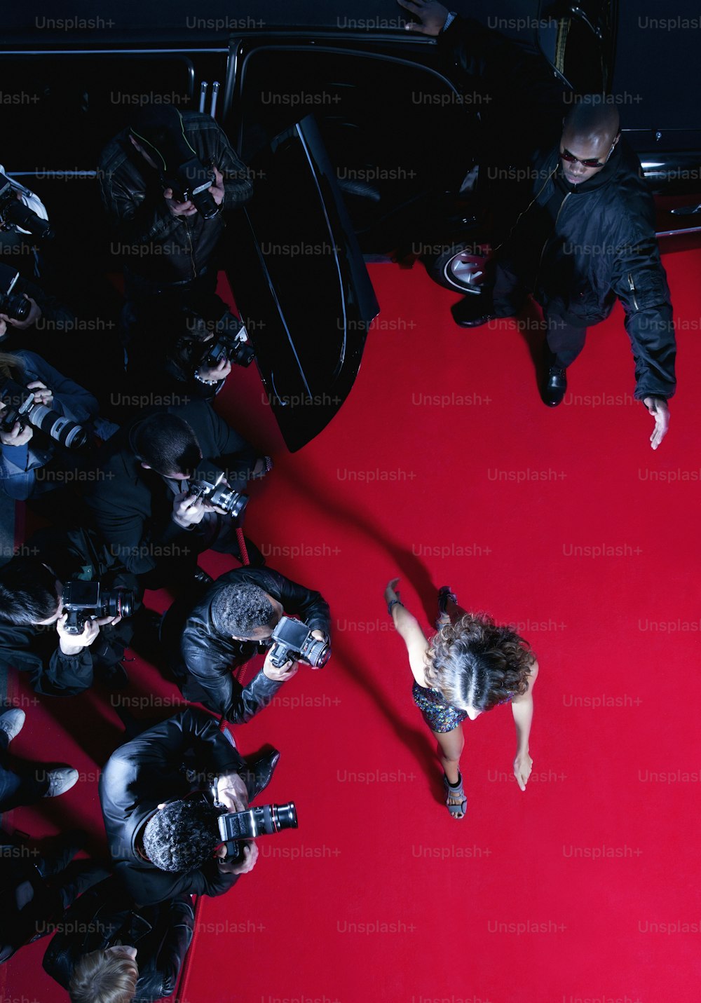 a group of people standing around a red carpet