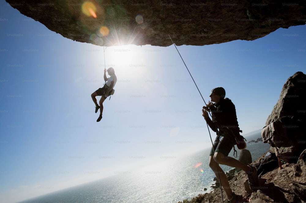a man on a rock climbing up a cliff