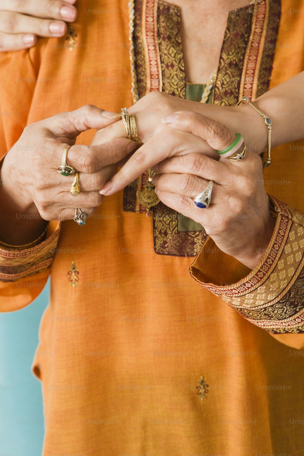 a woman in an orange shirt is holding a ring