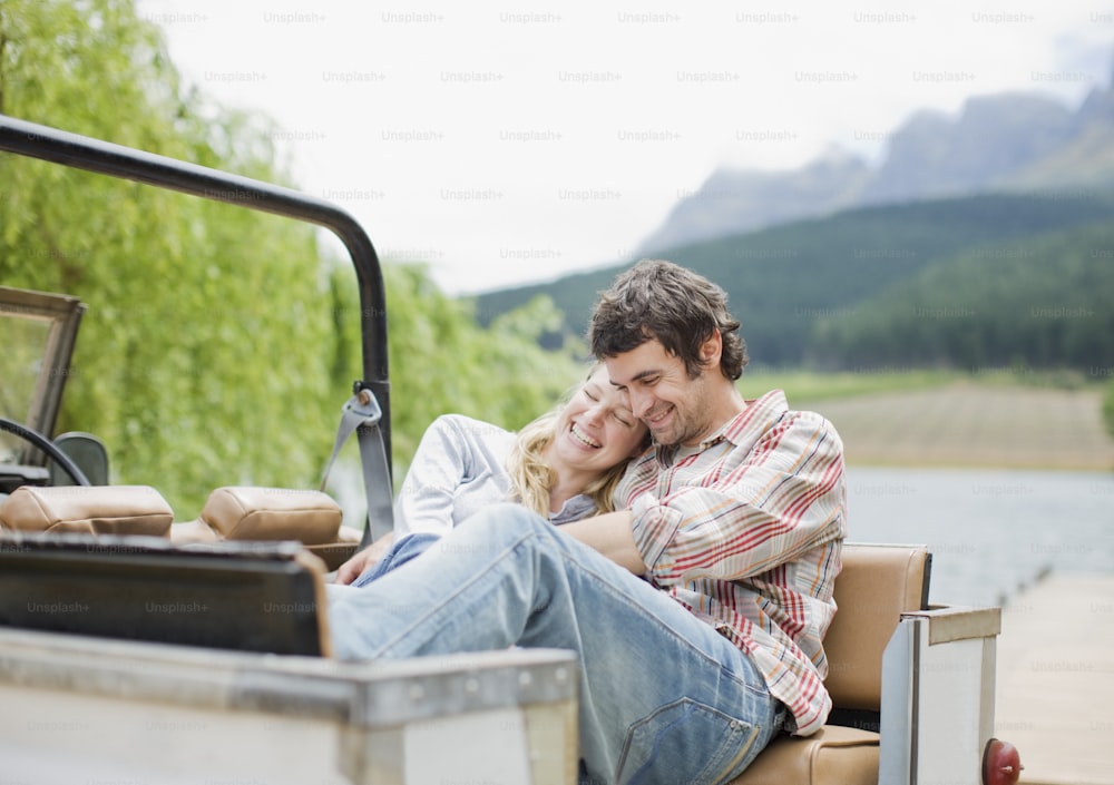 a man and woman sitting in the back of a truck