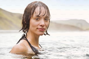 eine Frau mit nassen Haaren in einem Gewässer