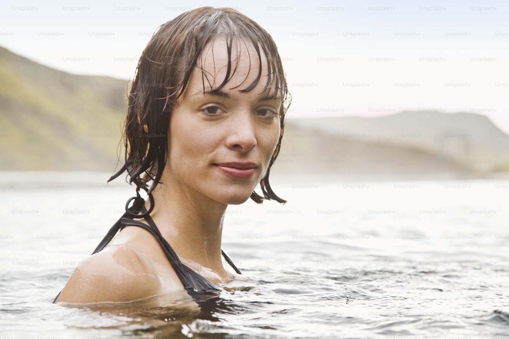 Una mujer con el pelo mojado en un cuerpo de agua