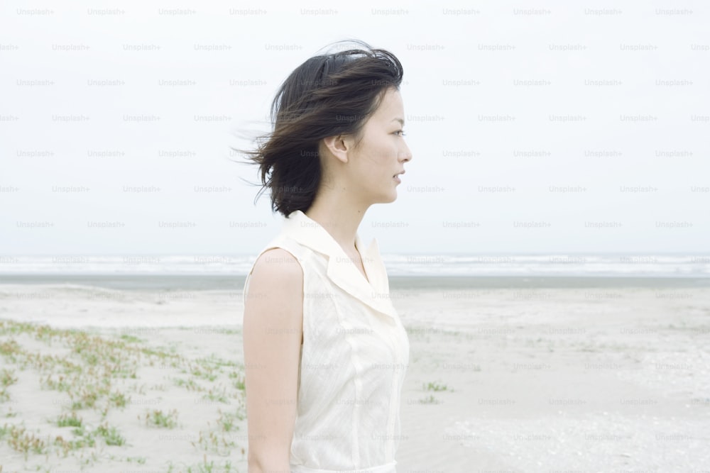 a woman standing on top of a sandy beach