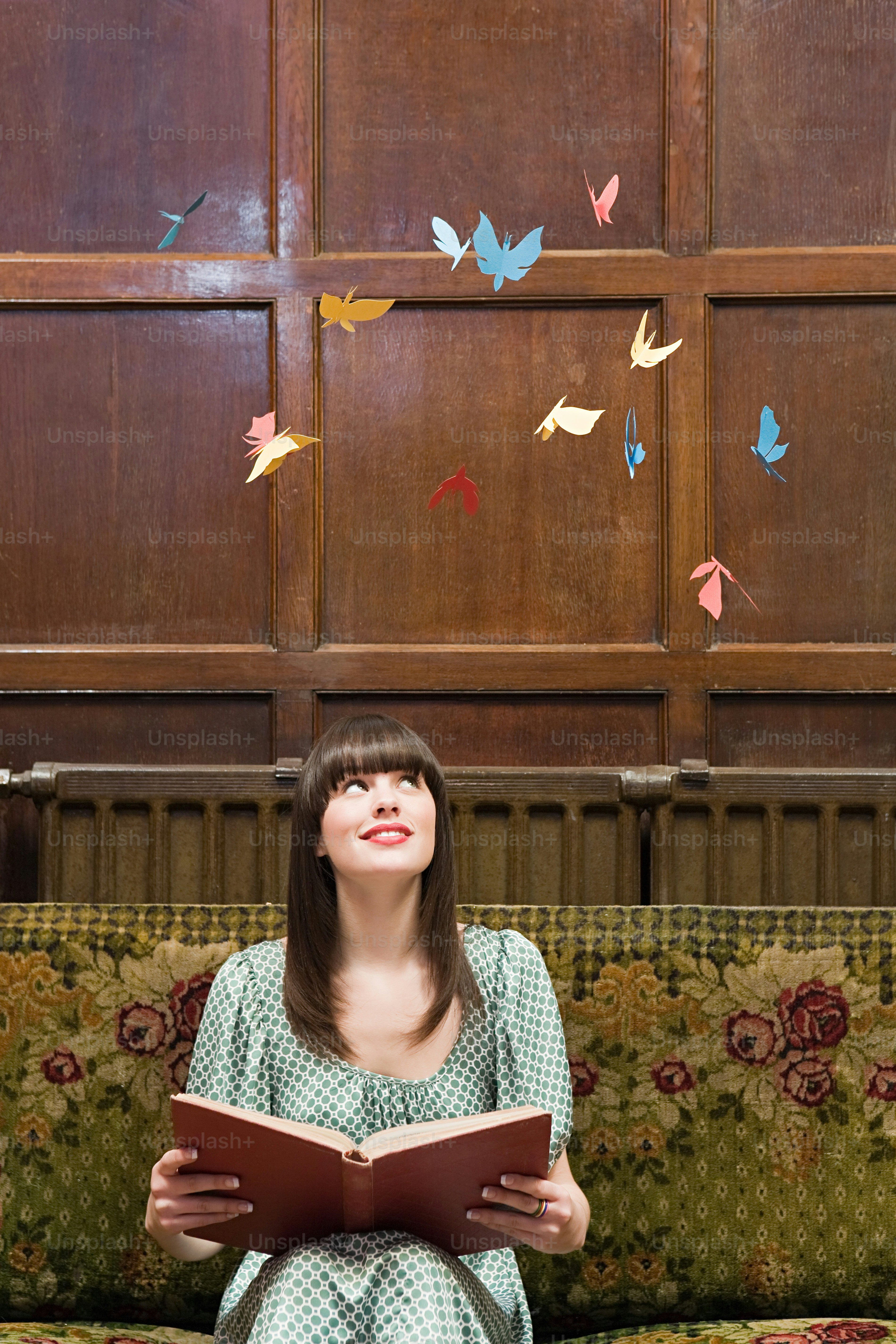 소파에 앉아 책을 읽고 있는 여자