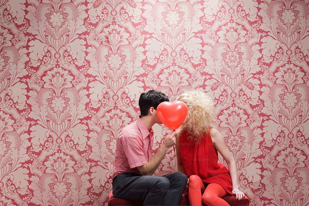 um homem e uma mulher sentados em um banco se beijando