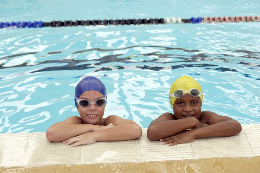 two children wearing swimming goggles in a swimming pool