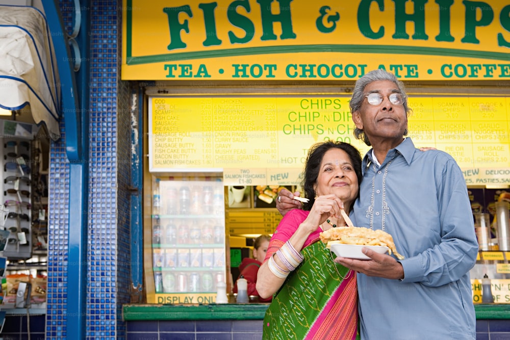 a man and woman standing in front of a restaurant