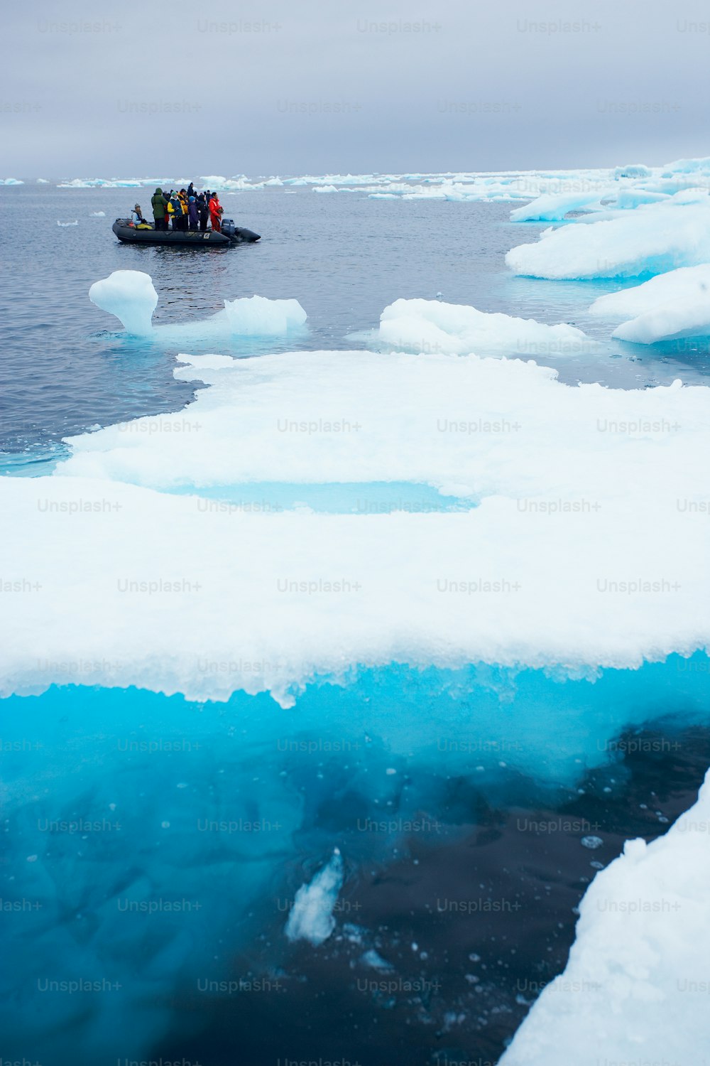 a group of people in a small boat on ice floes