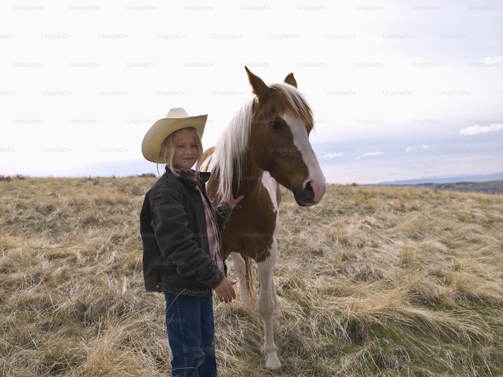 Cowgirl jovem autêntica no alcance com o cavalo em Big Timber, Montana